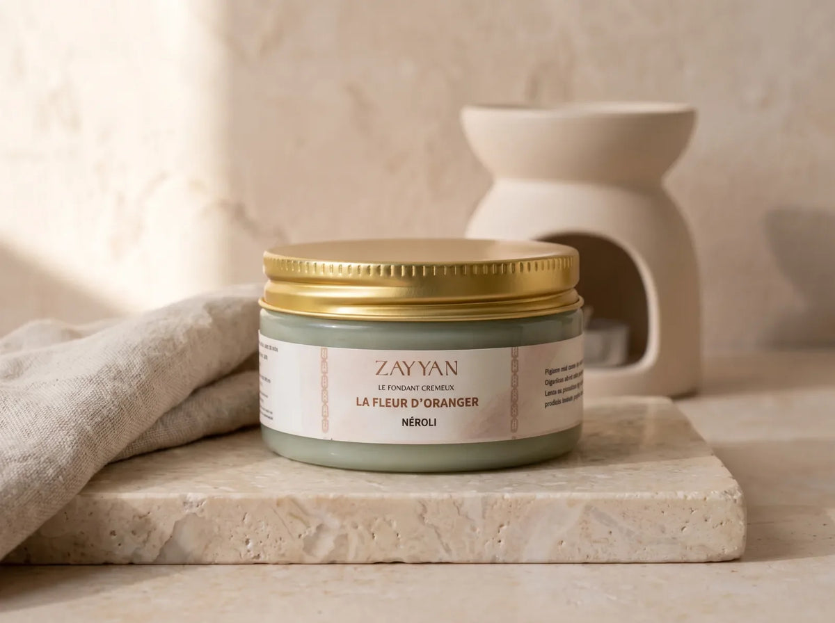 Fondant parfumé crémeux Zayyan sur du marbre clair, brûleur en céramique éteint en arrière plan