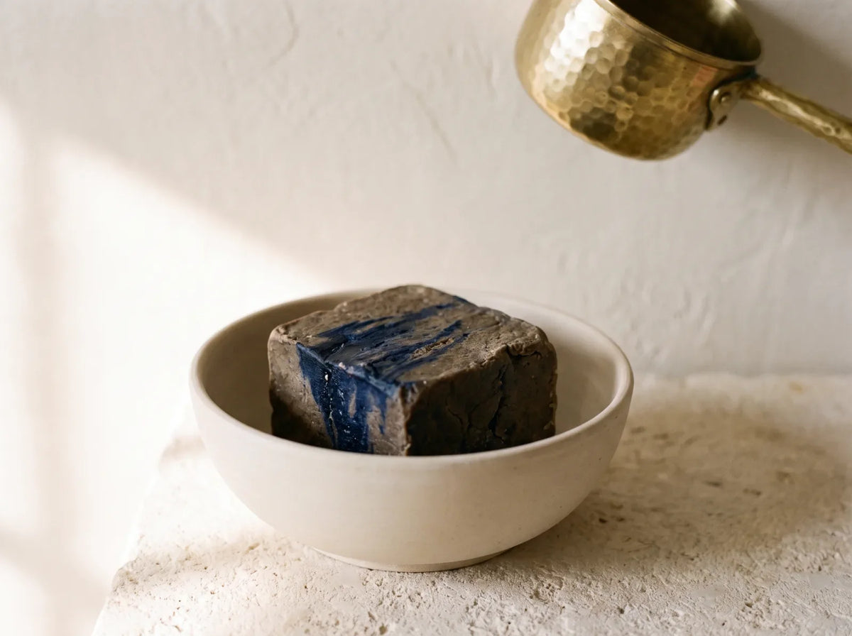 Savon noir beldi au Nila dans un bol de céramique, la pâte sombre veinée d'indigo