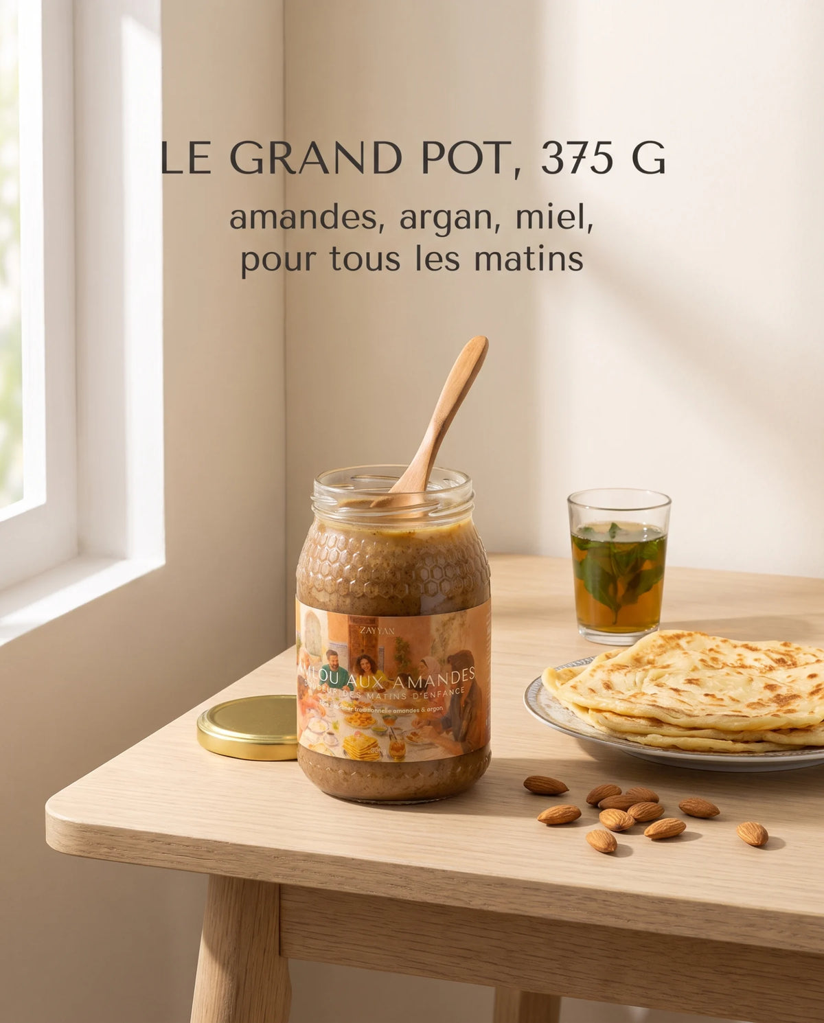 Grand pot d'amlou Zayyan de 375 g ouvert sur une table de petit-déjeuner, msemen et thé à la menthe