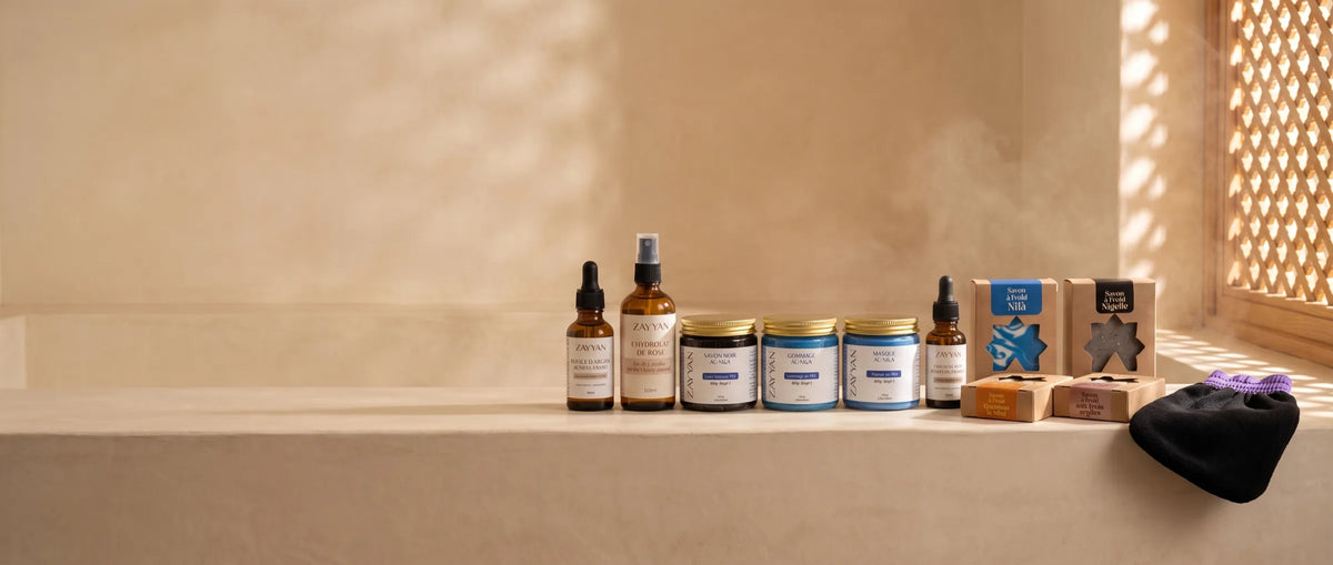 Rayon hammam et soins Zayyan : Pack Nila, hydrolat de rose, huiles et savons à froid sur un rebord en tadelakt