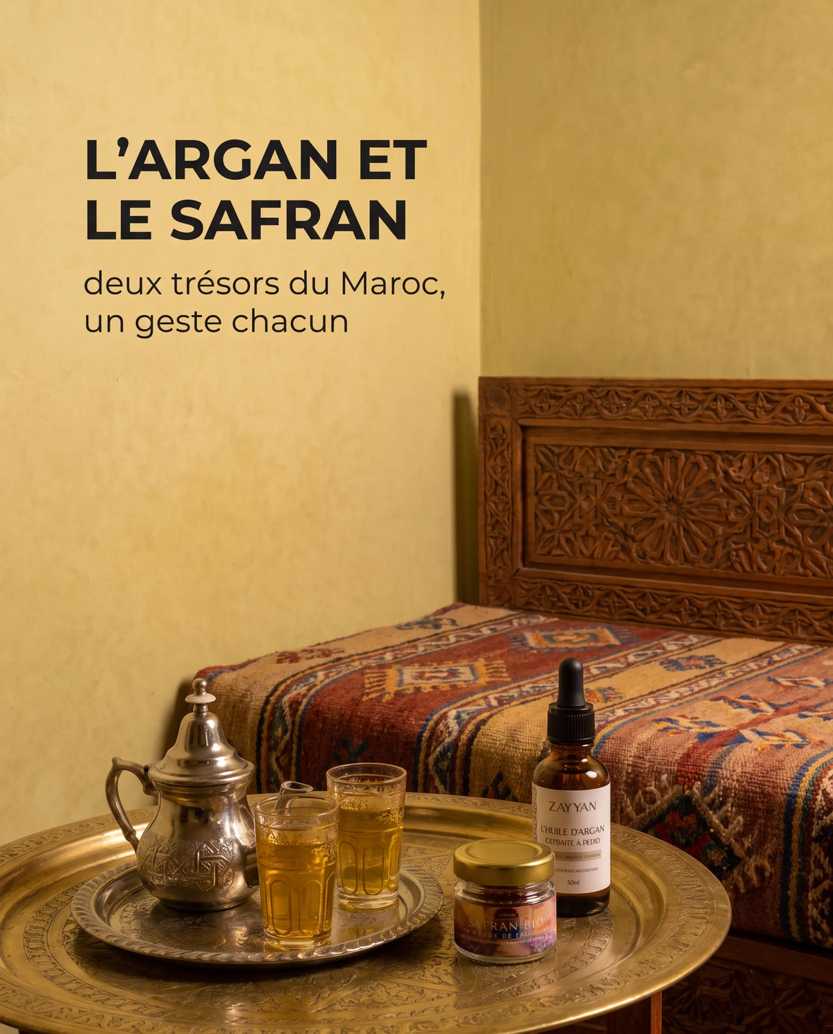 Huile d'argan et safran Zayyan sur un plateau en laiton, dans un salon marocain le soir
