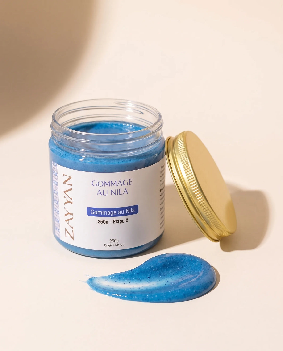 Gommage au Nila Zayyan, pot ouvert et texture bleue aux grains de coque d'argan