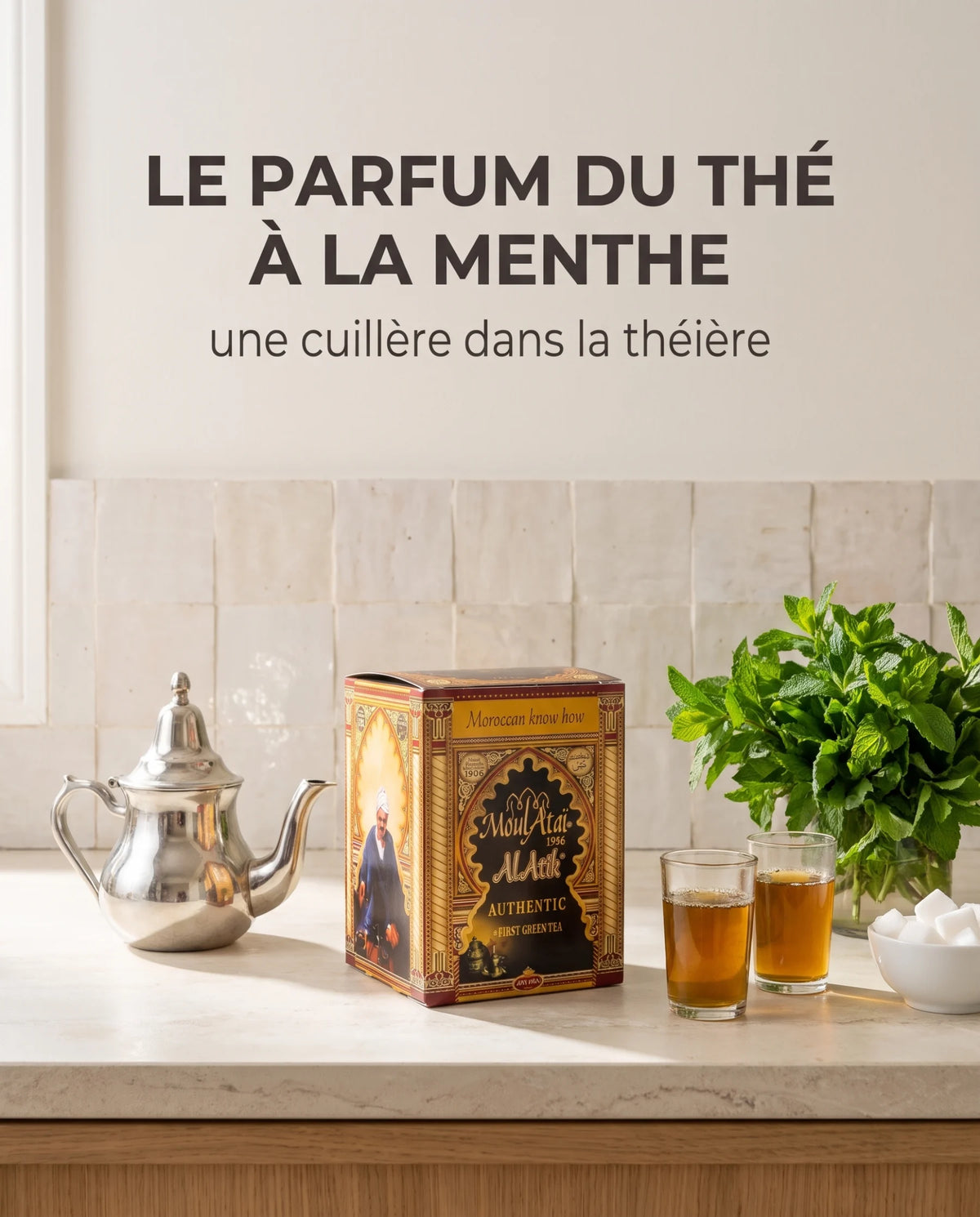 Boîte de thé El Atik, théière en argent, verres de thé et menthe fraîche sur un plan en pierre