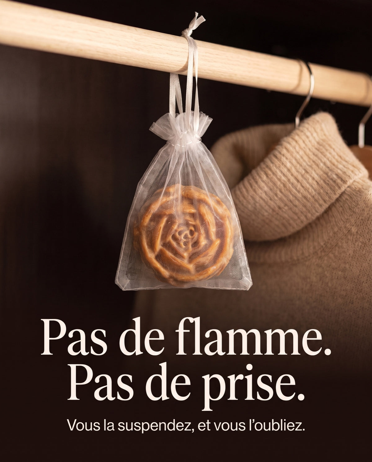 Le sachet en organza de la Fleur d'Ambre accroché à une tringle d'armoire, sans flamme ni prise électrique