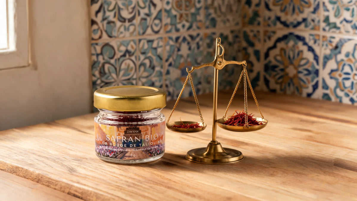 Pot de safran pur de Taliouine Zayyan à côté d'une petite balance en laiton portant une pincée de filaments rouges