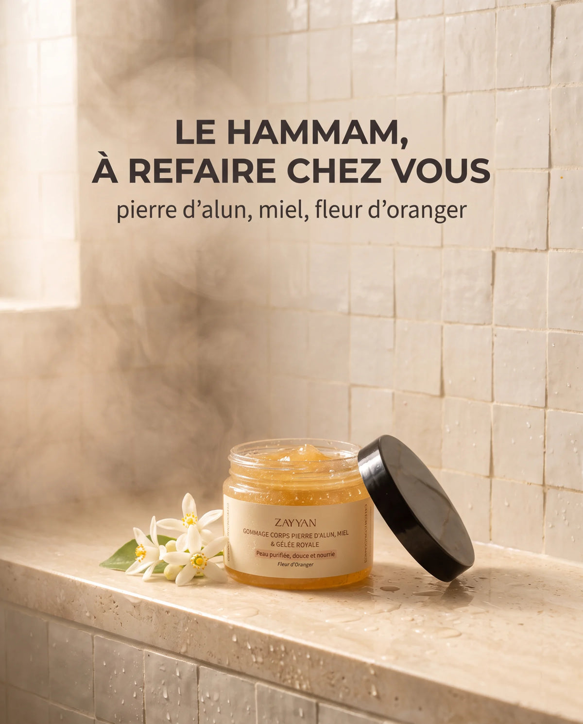 Gommage à la pierre d'alun Zayyan ouvert dans une douche en travertin, fleurs d'oranger et vapeur, le hammam à refaire chez vous